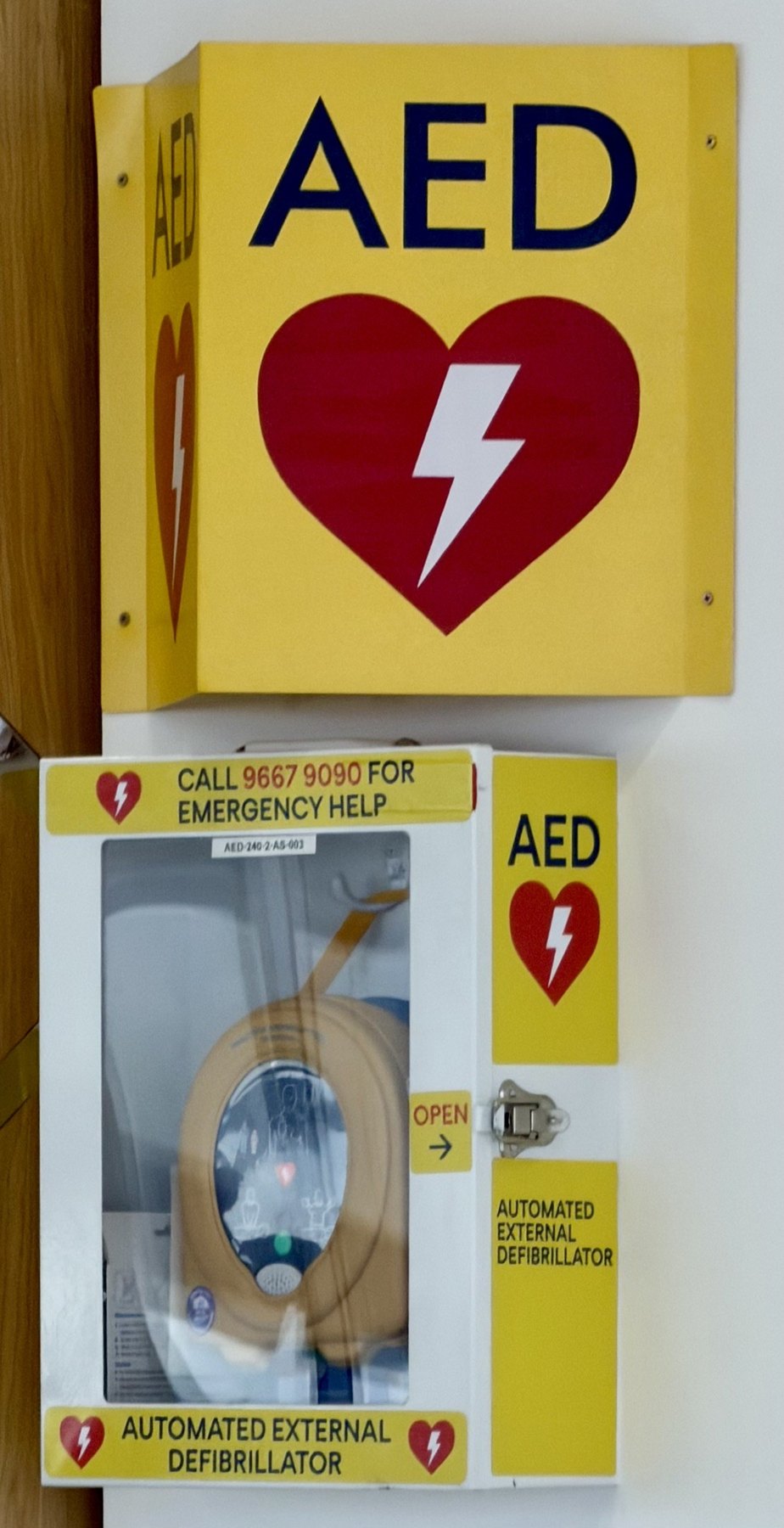 Yellow AED wall cabinet and automated external defibrillator.